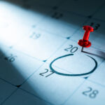 Red push pin on calendar with circle mark on 20